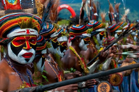 Members of a tribe in colourfully decorated costumes with face paint at the traditional sing-sing gathering
