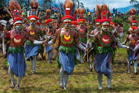 Members of a tribe in colourfully decorated costumes with face paint at the traditional sing-sing gathering