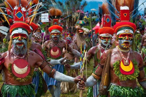 Members of a tribe in colourfully decorated costumes with face paint at the traditional sing-sing gathering
