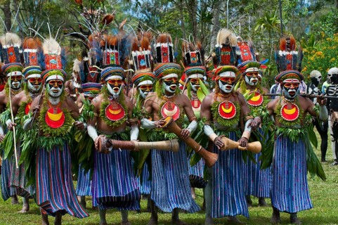 Men in colourfully decorated costumes with face paint are celebrating at the traditional Sing Sing gathering in the highlands