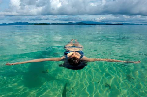 Tourist floating in the clear water of the Marovo Lagoon