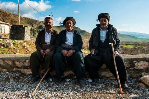 Kurdish men sitting on a wall