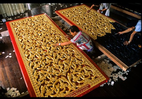 Craftsmen gilding doors with gold leaf