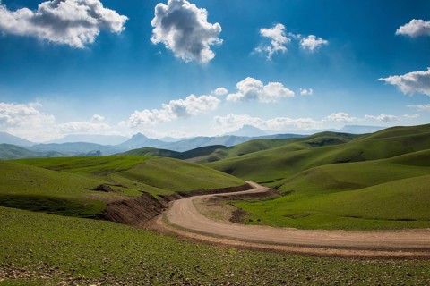 Road sneaking through the green hilly landscape