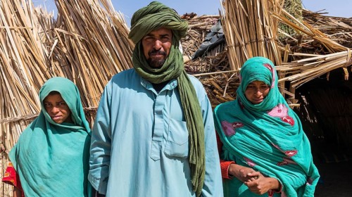 Tuareg family posing in front of their hut