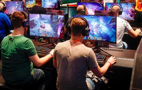 Visitors playing a computer game in front of screens