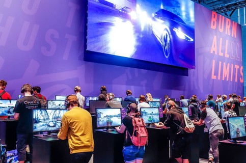 Teenagers at Need for Speed car racing game in front of screens