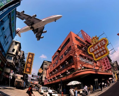 Thai Airways aircraft approaching Kai Tak Airport over the rooftops of Kowloon