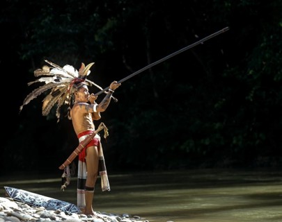 Head hunter of the ethnic group of the Iban people with a blowpipe