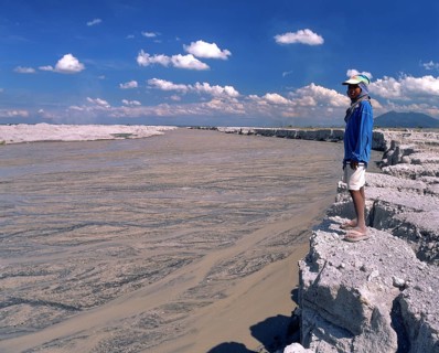 Boy standing on the bank of a mudstream