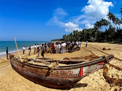 Fishing boat and fishermen on the beach
