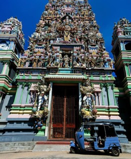 Tuk tuk in front of the gopuram or gate tower at the entrance to the Hindu temple of Colombo II