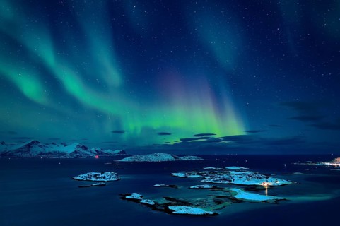 Fjord with islands in winter and the northern lights