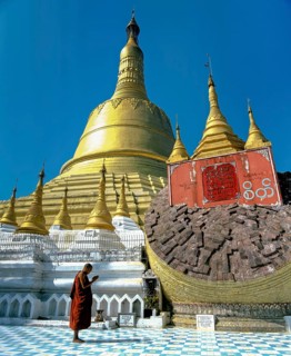 Monk praying in front the Shwemawdaw Paya pagoda