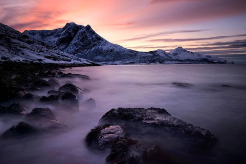 Fjord with mountain range in the evening light in winter