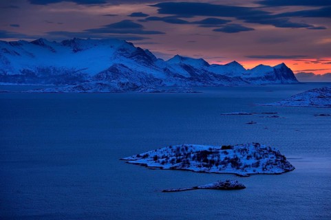 Fjord with mountains in winter at sunset
