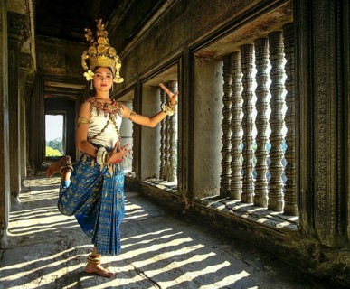 Temple dancer or apsara posing in front of the baluster windows in the temple of Angkor Wat
