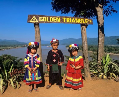 Hilltribe children before sign 'Golden Triangle'