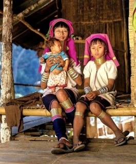 Long-necked woman with a girl and a baby of the Padaung mountain tribe