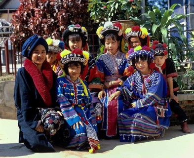 A group of children from the Lisu hill tribe wearing traditional costumes and headdresses