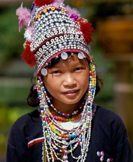 Akha girl wearing a colourful headdress and the traditional costume of the mountain people