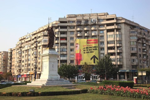 Prefabricated concrete apartment building with a large advertising poster for a hardware store