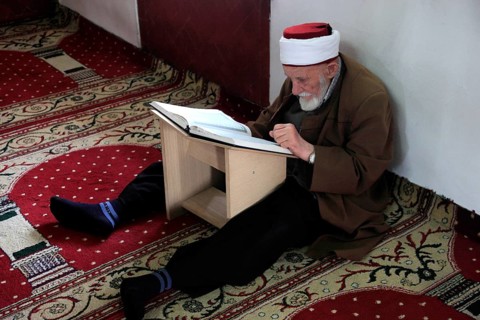 Muslim man studying the Quran in the Et'hem Bey Mosque