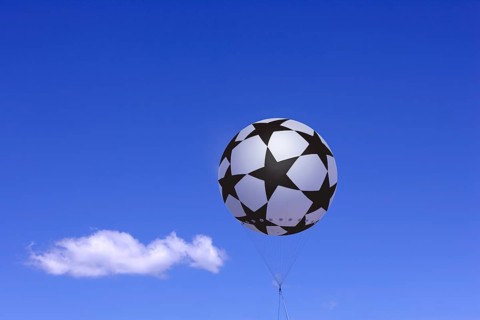 Tethered balloon with the Champions League logo against a blue sky with a cloud