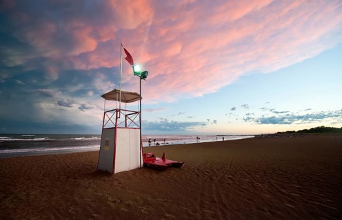 Observation tower on the sea with moody clouds and the afterglow of sunset