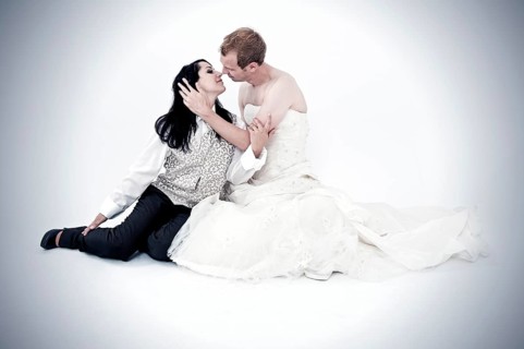 Bride wearing a suit kissing a groom wearing a wedding dress