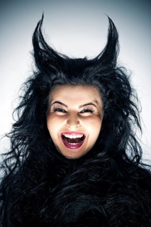 Laughing young woman dressed as a devil with horns
