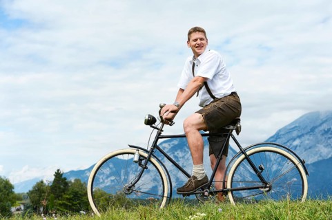 Man wearing leather pants on an old bicycle