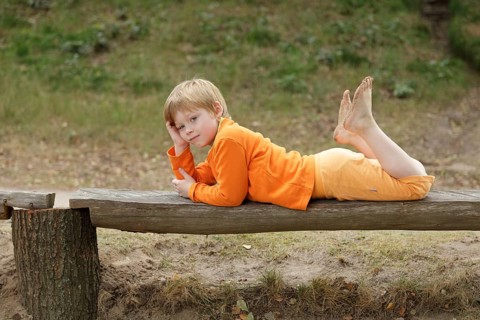 Little boy lying on a bench