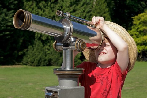Young boy looking through a telescope
