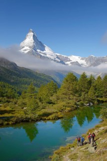 Hikers taking photographs of the Matterhorn with Lake Grindjisee in the foreground