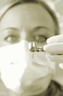 Dentist wearing a face mask and holding a drill