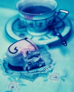 Half-eaten heart-shaped petit four and an old coffee cup