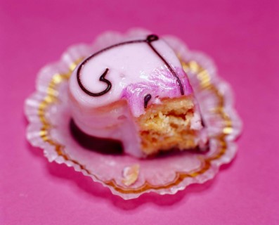 Half-eaten pink heart-shaped petit four