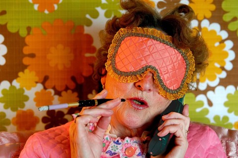 Old lady with sleep blindfold and cigarette with a holder