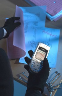 Burglar using a camera phone to take a photograph of secret plans