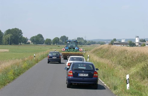 Cars overtaking a tractor on a country road