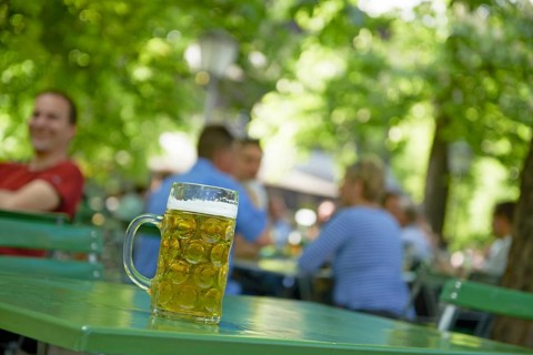 Full beer mug on a table in a beer garden