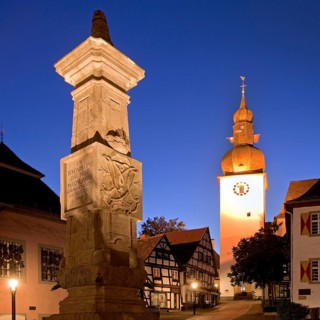 Maximilian Fountain in Alter Markt square with the old town hall and the bell tower at dusk