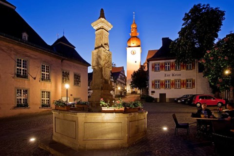Maximilian Fountain in Alter Markt square with the old town hall and the bell tower at dusk