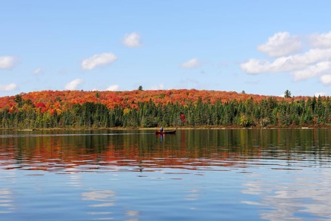 Canoe Lake with canoeists and a forest in autumn colours