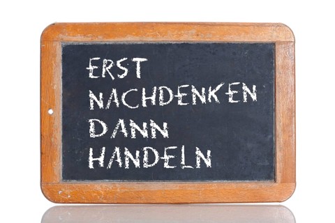 Old school blackboard with the phrase ERST NACHDENKEN DANN HANDELN
