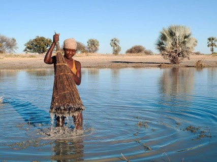 Ovambo girl fishing in a shallow pond
