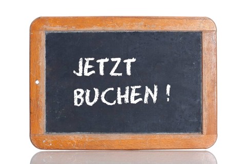 Old school blackboard with the words JETZT BUCHEN!