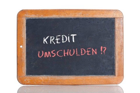 Old school blackboard with the words KREDIT UMSCHULDEN!?
