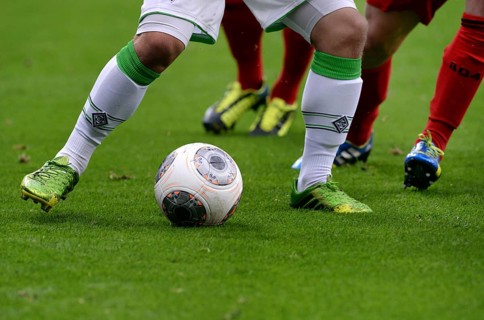 Legs of players from Borussia Moenchengladbach and Bayer Leverkusen with a ball